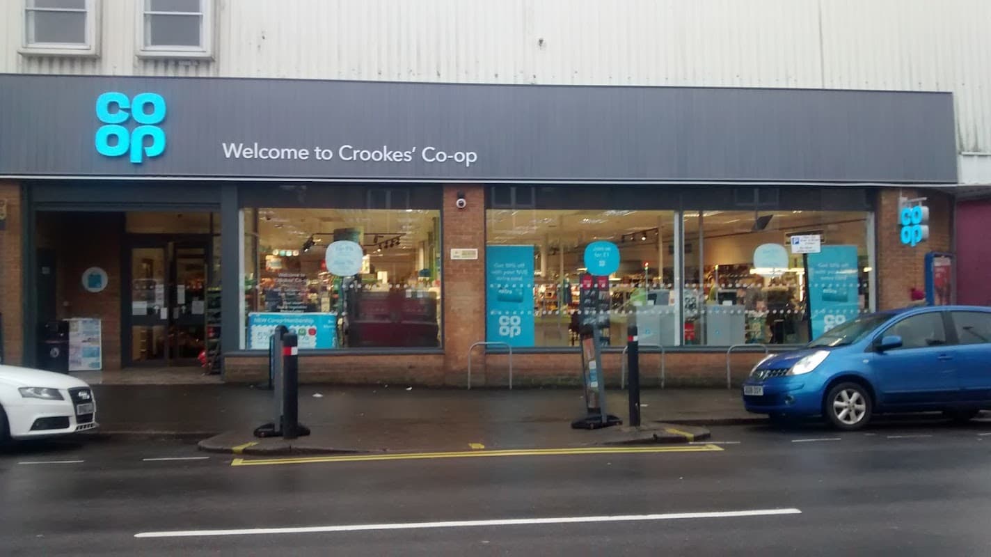 Co-op Food store in Sheffield with large windows, welcoming sign, and parked cars outside.