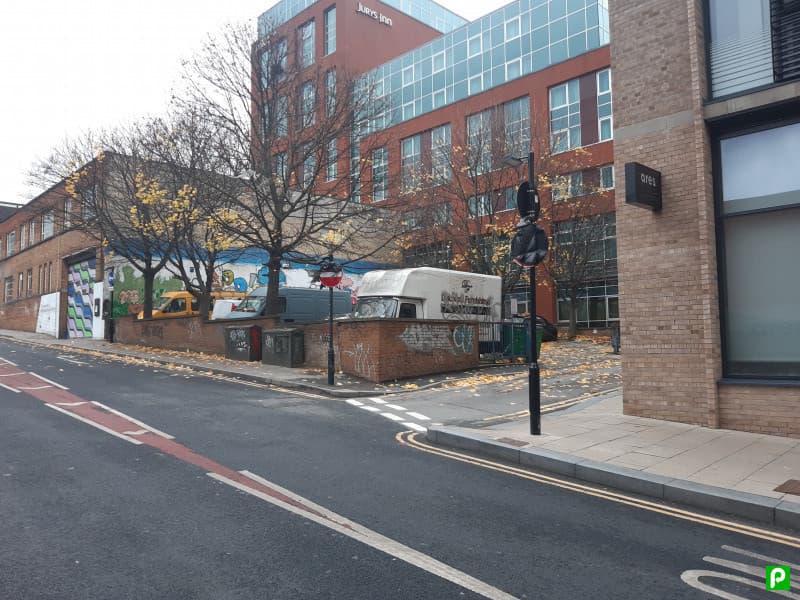 DesParking Eyre Lane Car Park with Pay & Display sign, autumn leaves, and a mix of vehicles and buildings in Sheffield.