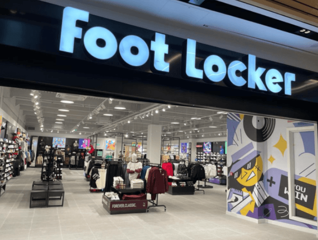 Foot Locker store entrance with bright signage, showcasing athletic shoes and apparel inside a modern retail space.