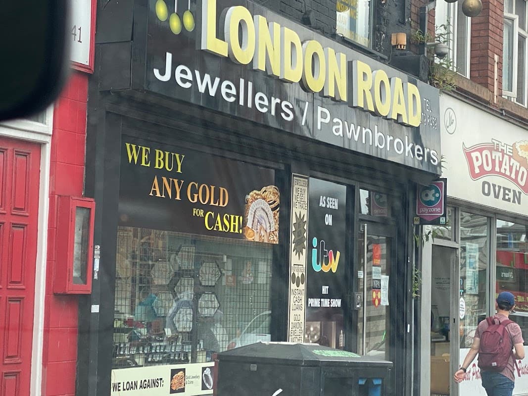 London Road Jewellers storefront with bold signage, gold jewelry display, and a "We Buy Any Gold for Cash" banner.