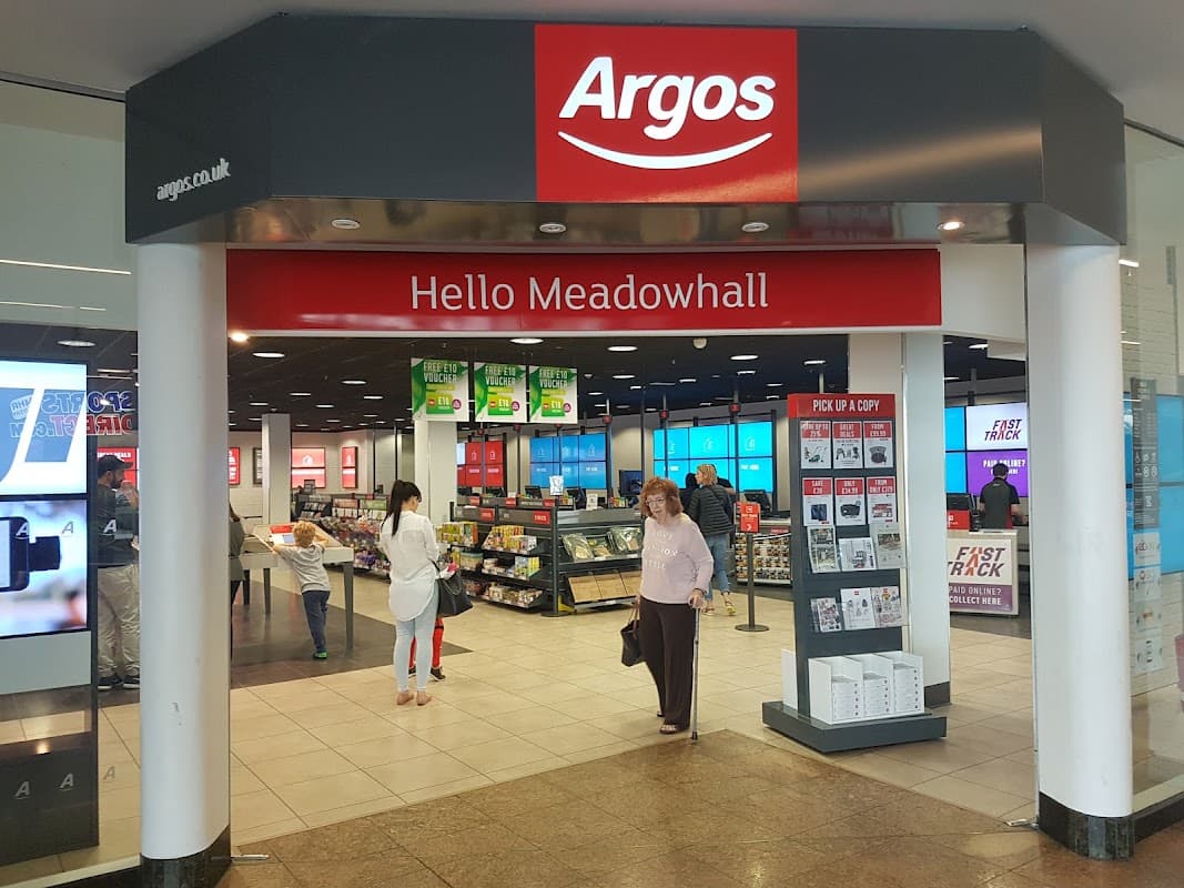 Argos store entrance with "Hello Meadowhall" sign, displays of homeware and electronics, and customers browsing.