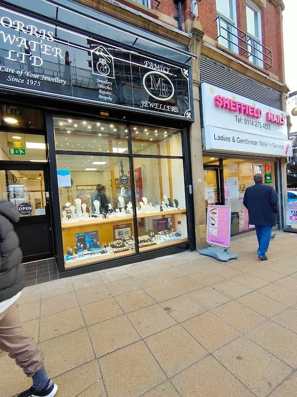 Jewellery shop window displaying various pieces, with "Morris Bywater Ltd" and "Family Jewellers" signage.
