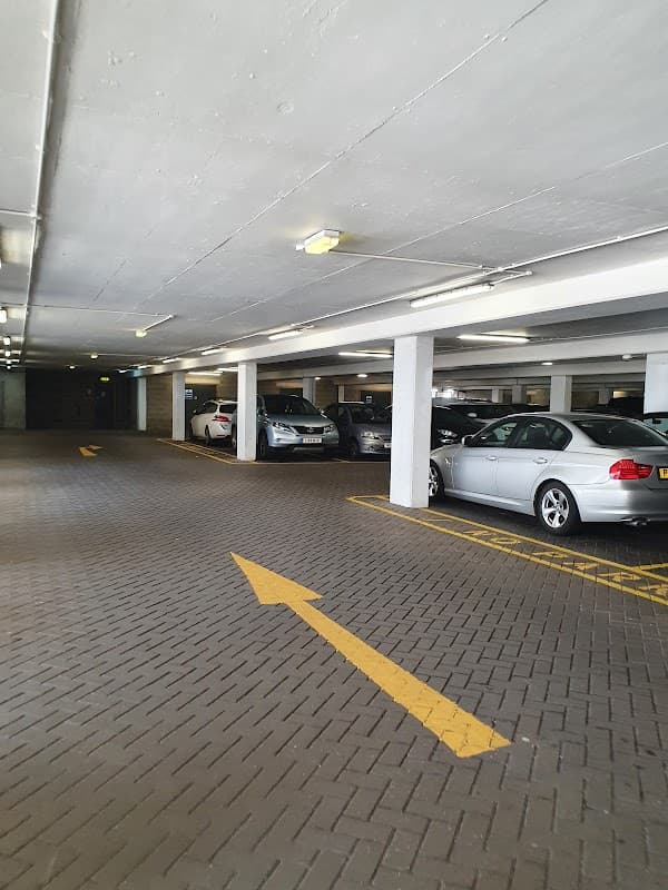 Ponds Forge car park with parked cars, marked lanes, and bright overhead lights in a spacious, well-maintained area.