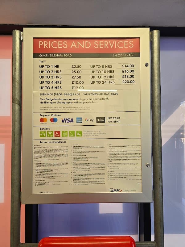 Pricing and services sign for Q-Park Durham Road, detailing parking rates and payment options. Open 24/7.