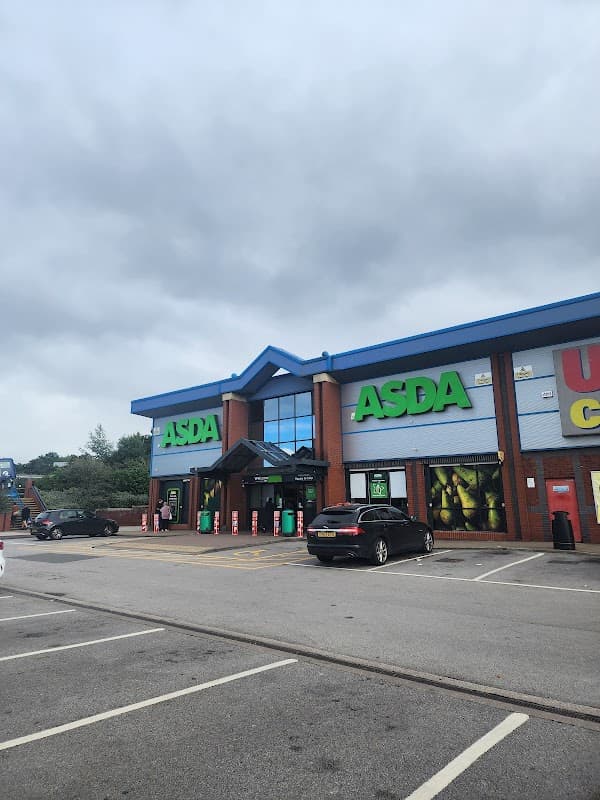 ASDA store with green signage, parked cars, and a cloudy sky at Queens Road Retail Park, Sheffield.