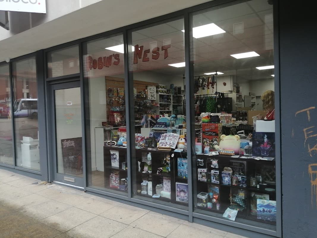 Storefront of Robin's Nest Comics with glass display showcasing various comic books and collectibles.
