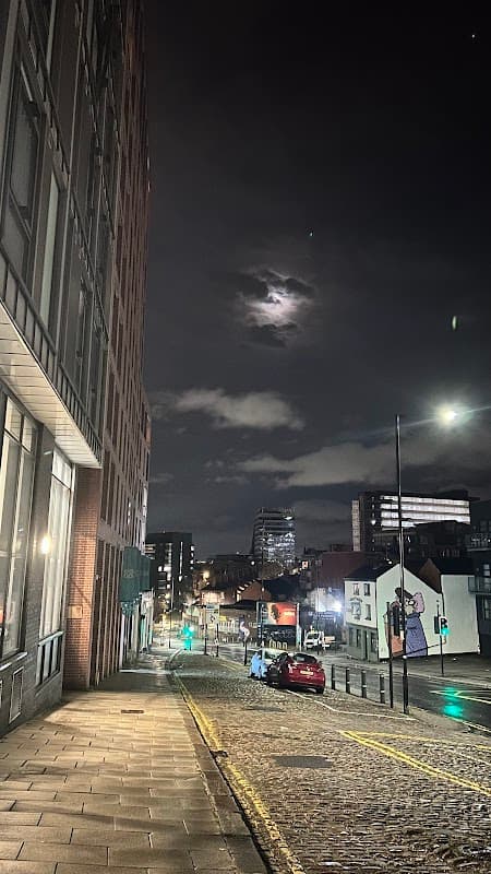 Nighttime view of Setts Car Parking Place, with cobbled street, moonlit sky, and city buildings in Sheffield.
