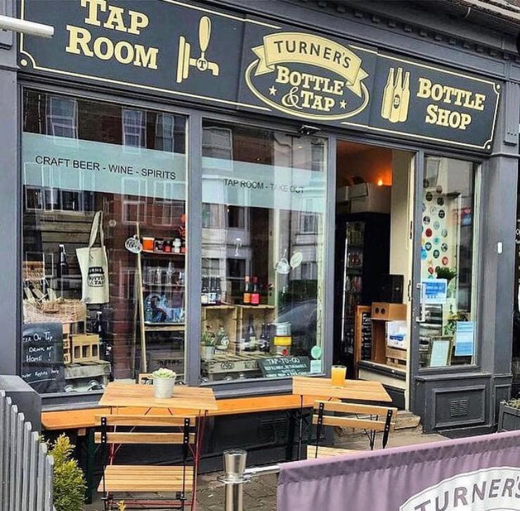 Turner's Craft Beer Bottle Shop features a stylish storefront with wooden benches, showcasing craft beer and spirits.