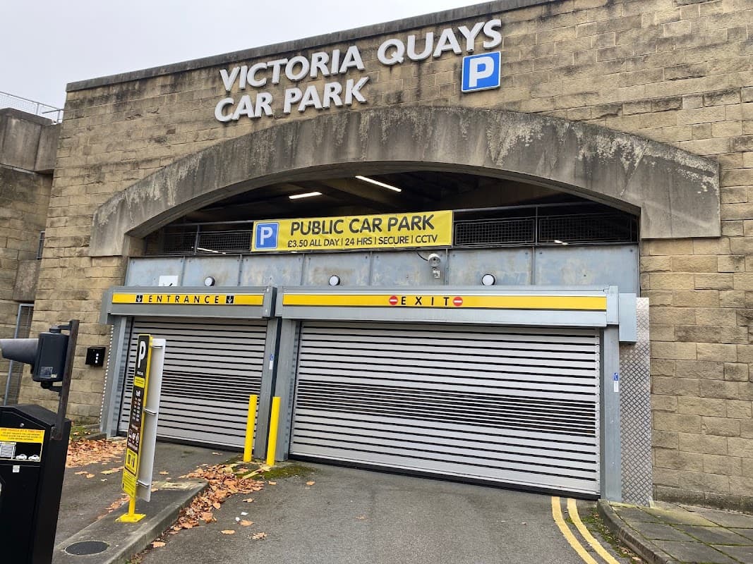 Victoria Quays Car Park entrance with signage, roller doors, and a parking fee notice in Sheffield, Yorkshire.