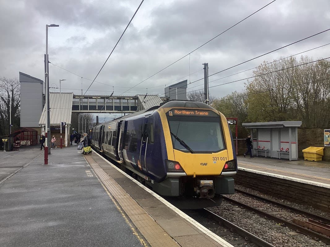 Northern Trains train at Shipley station, with platforms, shelter, and overcast sky in the background.
