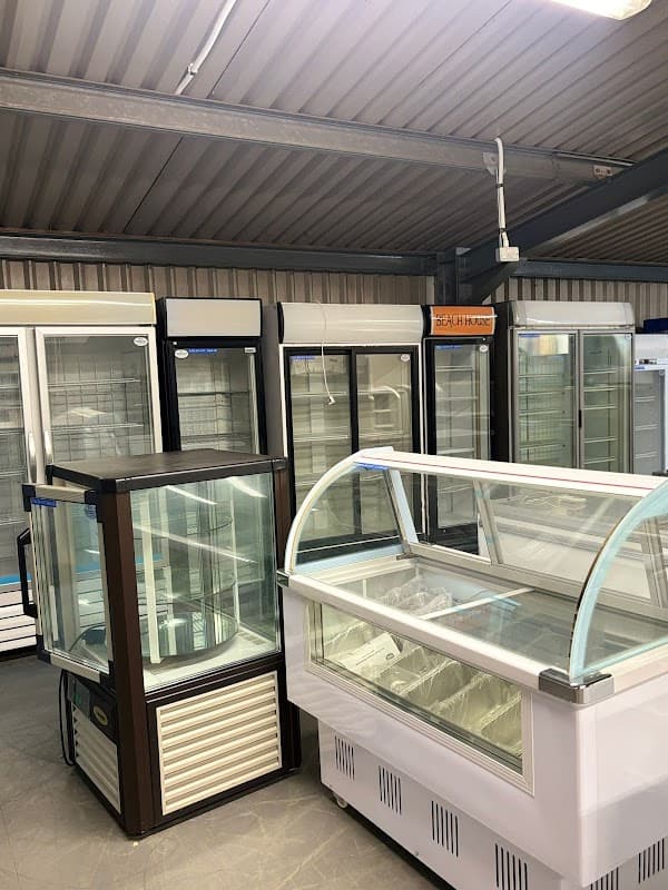 Display of various refrigeration units, including glass-fronted freezers and ice cream cabinets, in a warehouse setting.