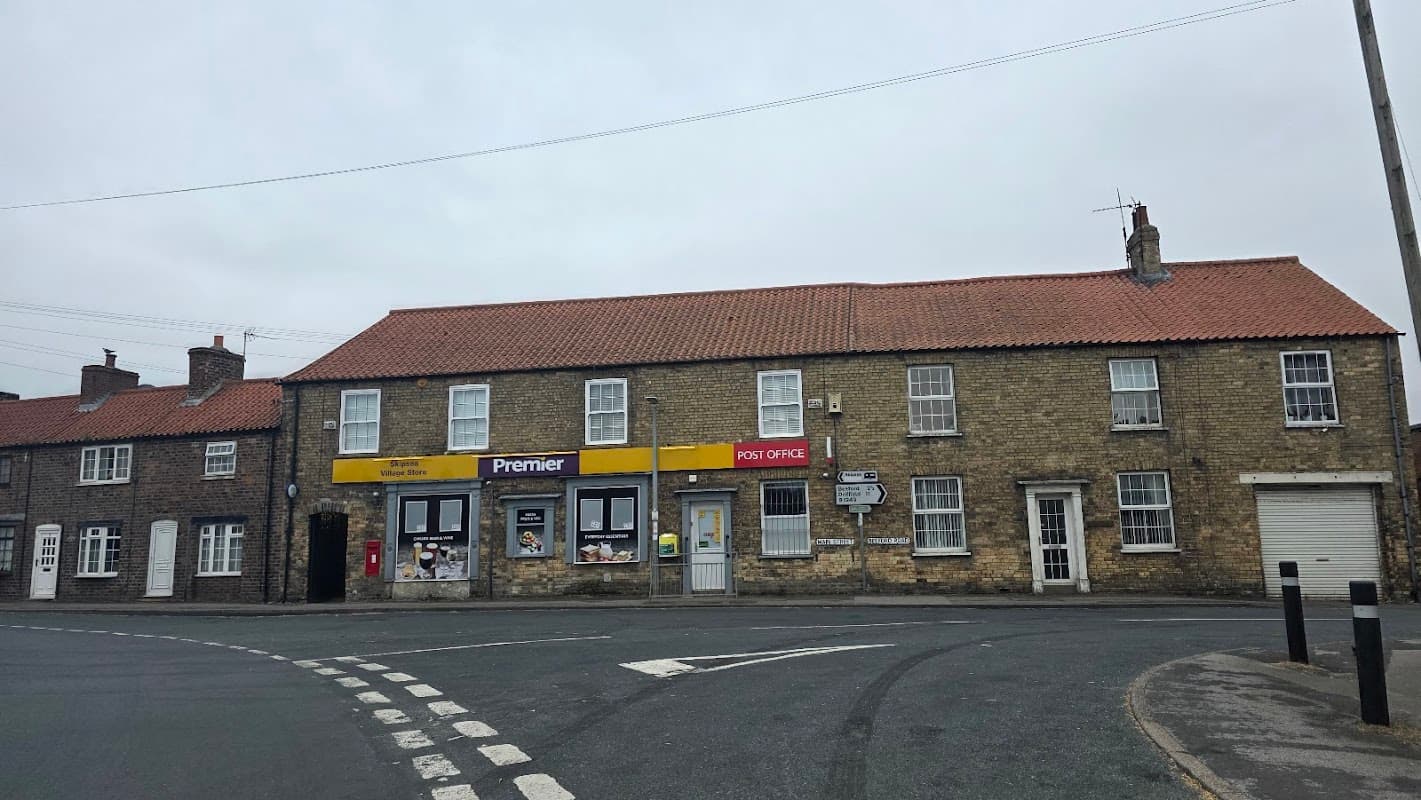 Premier-branded shop with a yellow sign, Post Office signage, and stone buildings on a quiet street in Skipsea, Yorkshire.