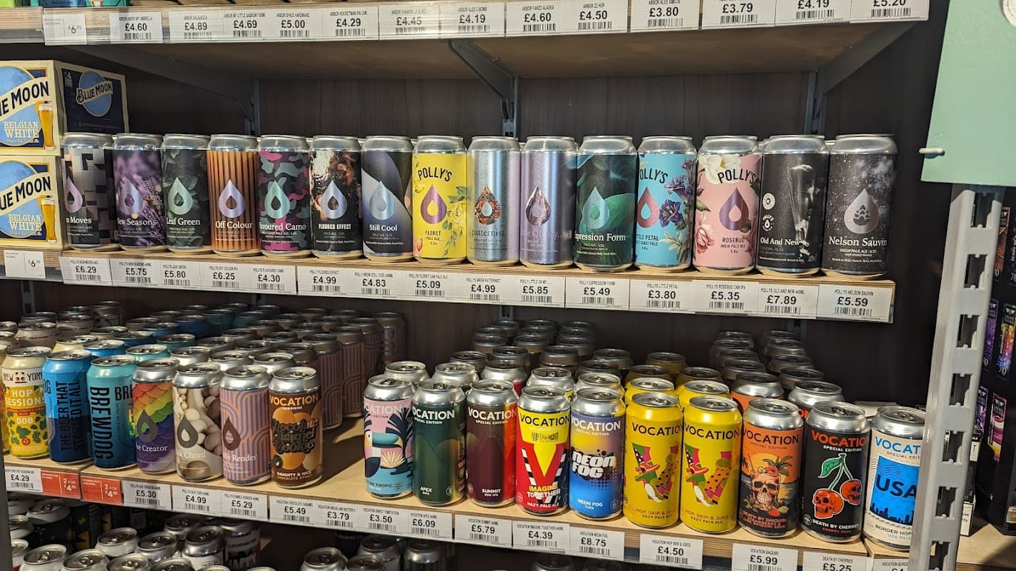 Colorful cans of craft beer displayed on wooden shelves at Wine Rack, a shop in Skipton, Yorkshire.