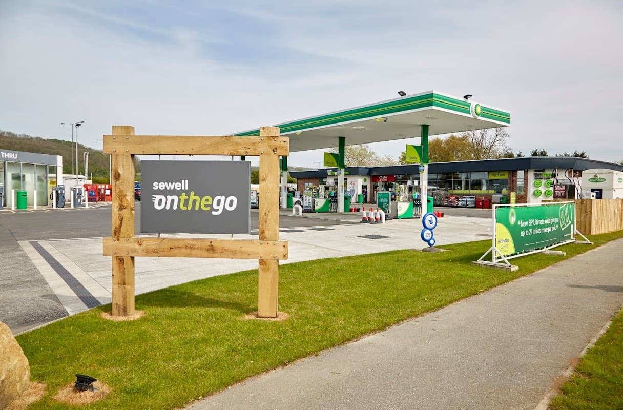 Sewell on the go sign in front of a petrol station with fuel pumps and green canopies in South Cave, Yorkshire.