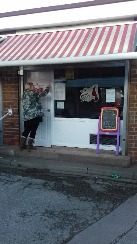 A person in a camouflage jacket opens a door with a striped awning above, near a colorful "OPEN" sign.