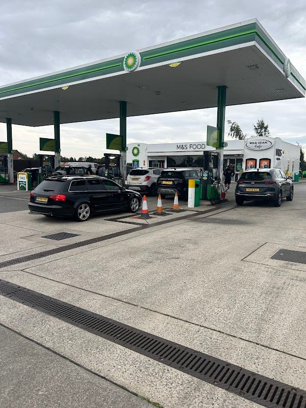 BP gas station with M&S Food shop, cars at pumps, and a cloudy sky in South Milford, Yorkshire.