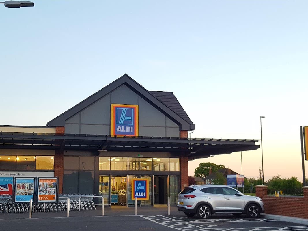 ALDI store in Sowerby, North Yorkshire, featuring a modern facade and parked car in the foreground at dusk.
