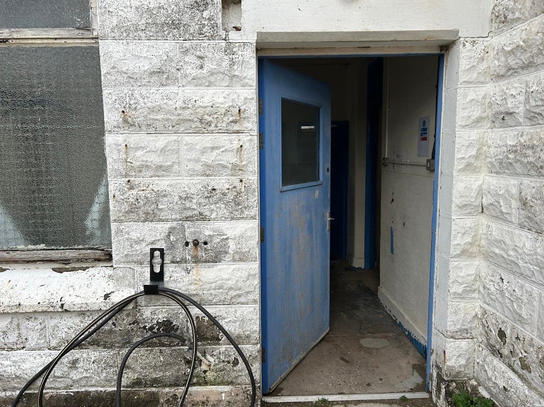 Entrance to a public toilet facility with a blue door and stone walls, located at Spurn Head, Yorkshire.
