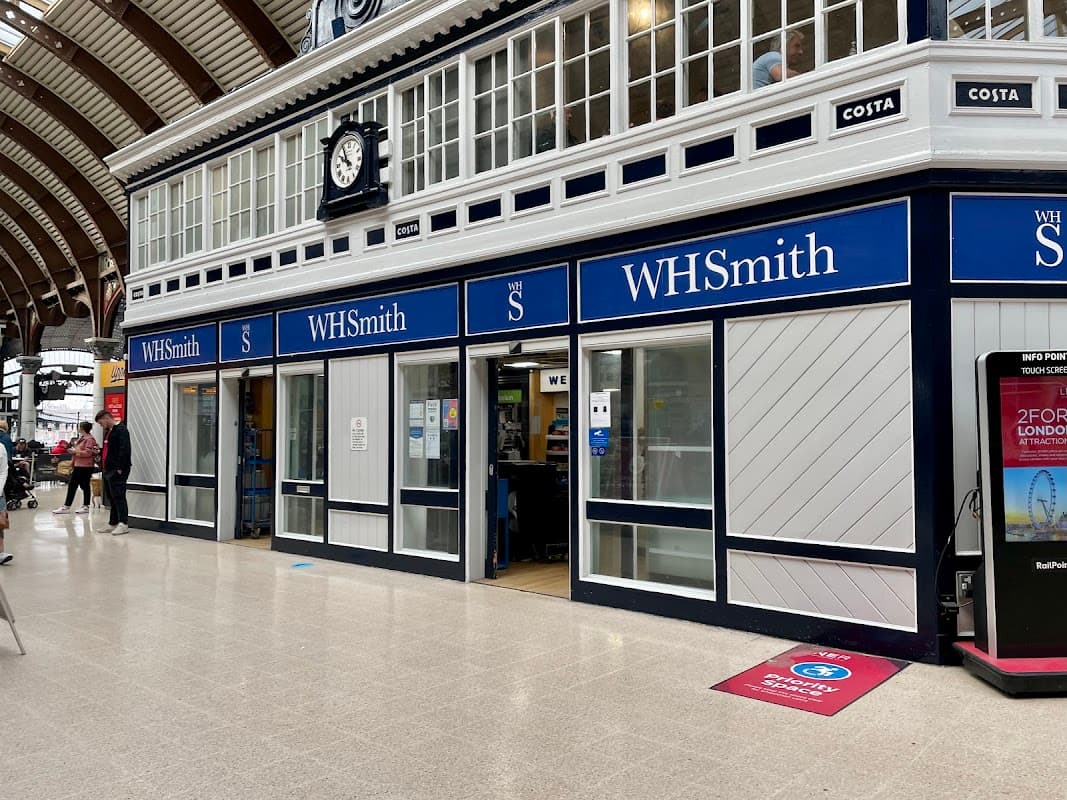 WHSmith shop front in Starbeck, Yorkshire, featuring large windows, blue signage, and a clock above the entrance.