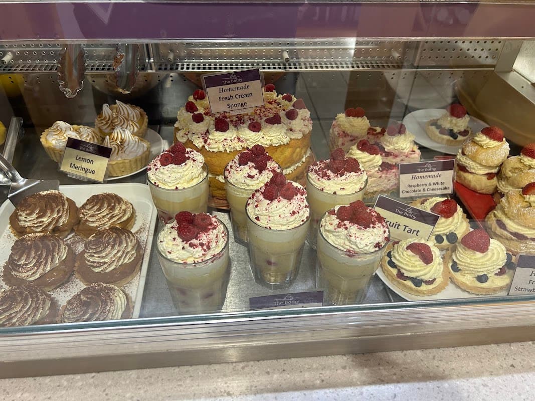 Delicious desserts display featuring cream sponge, fruit tart, meringues, and raspberry parfaits at The Bothy.