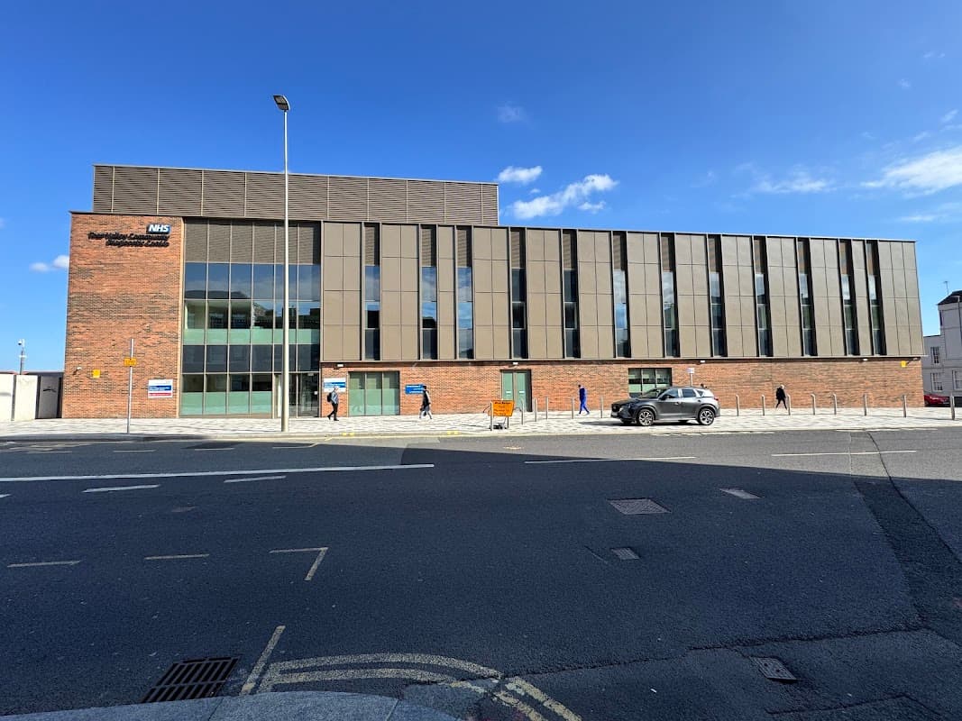 Modern brick building with large windows, on-street parking, and clear blue sky in Tees Valley, Yorkshire.