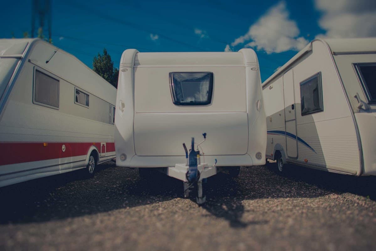 Caravans parked closely together at Teesside Caravan Storage Ltd under a blue sky with scattered clouds.