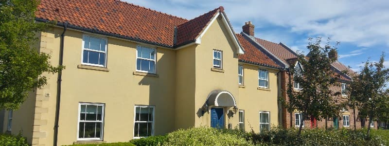 Clara's Den Holiday Apartment features a yellow exterior, red-tiled roof, and landscaped greenery in The Bay, Filey.