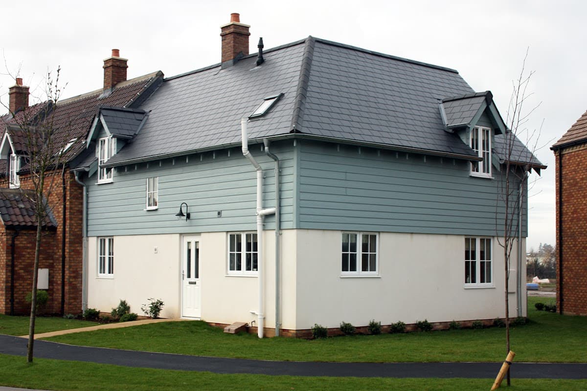 Lovesea Lodge, a two-story house with a blue exterior, white trim, and a well-maintained lawn in Filey, Yorkshire.