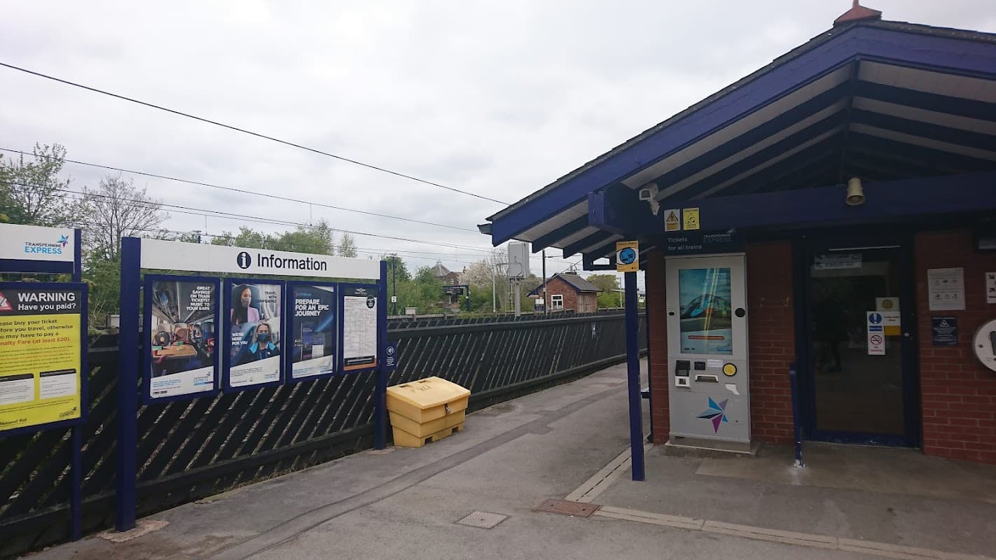 APCOA Charging Station at Thirsk station, featuring information signage and a modern building structure.