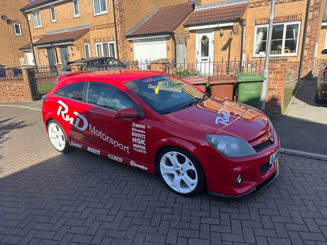 Red modified car with "RnD Motorsport" branding parked on a residential street in Tholthorpe, Yorkshire.