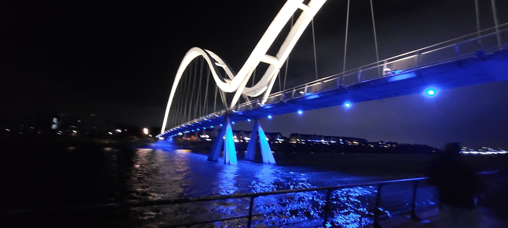 Illuminated bridge over water at night, with blue lights and dark sky, near Stockton-on-Tees Borough Council.