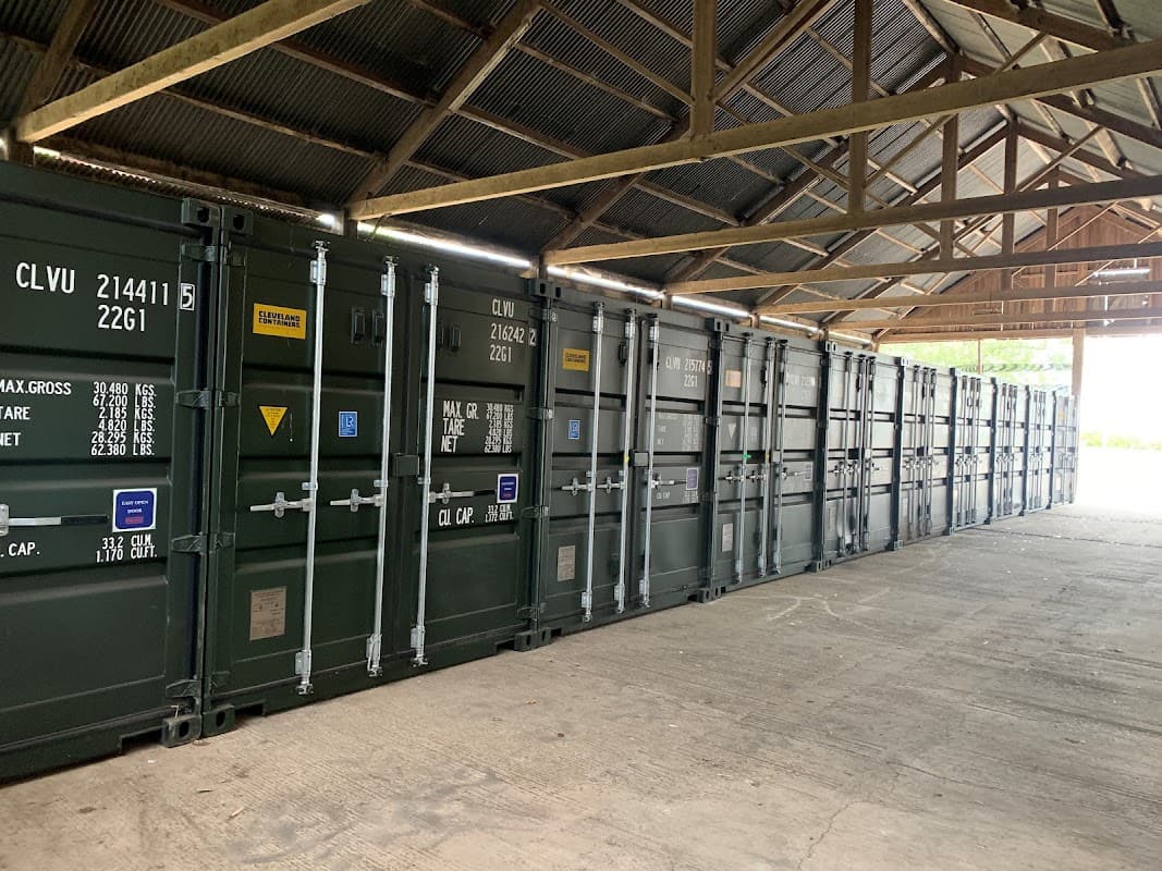 Storage containers lined up under a wooden roof in Chapel Hill Storage, Thornborough, North Yorkshire.