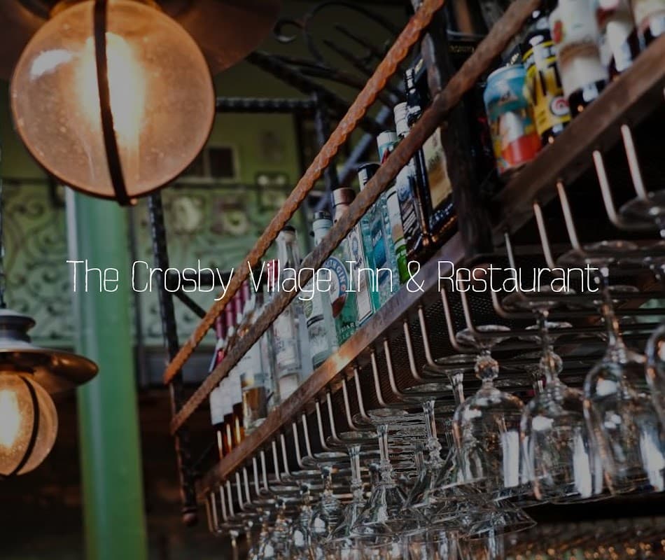 Bar shelves lined with various bottles and hanging glasses, featuring rustic decor in a cozy atmosphere.