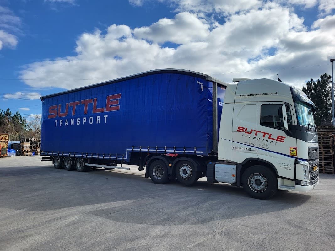 Suttle Transport truck parked at a Pay & Display area in Tockwith, Yorkshire, with a clear blue sky above.