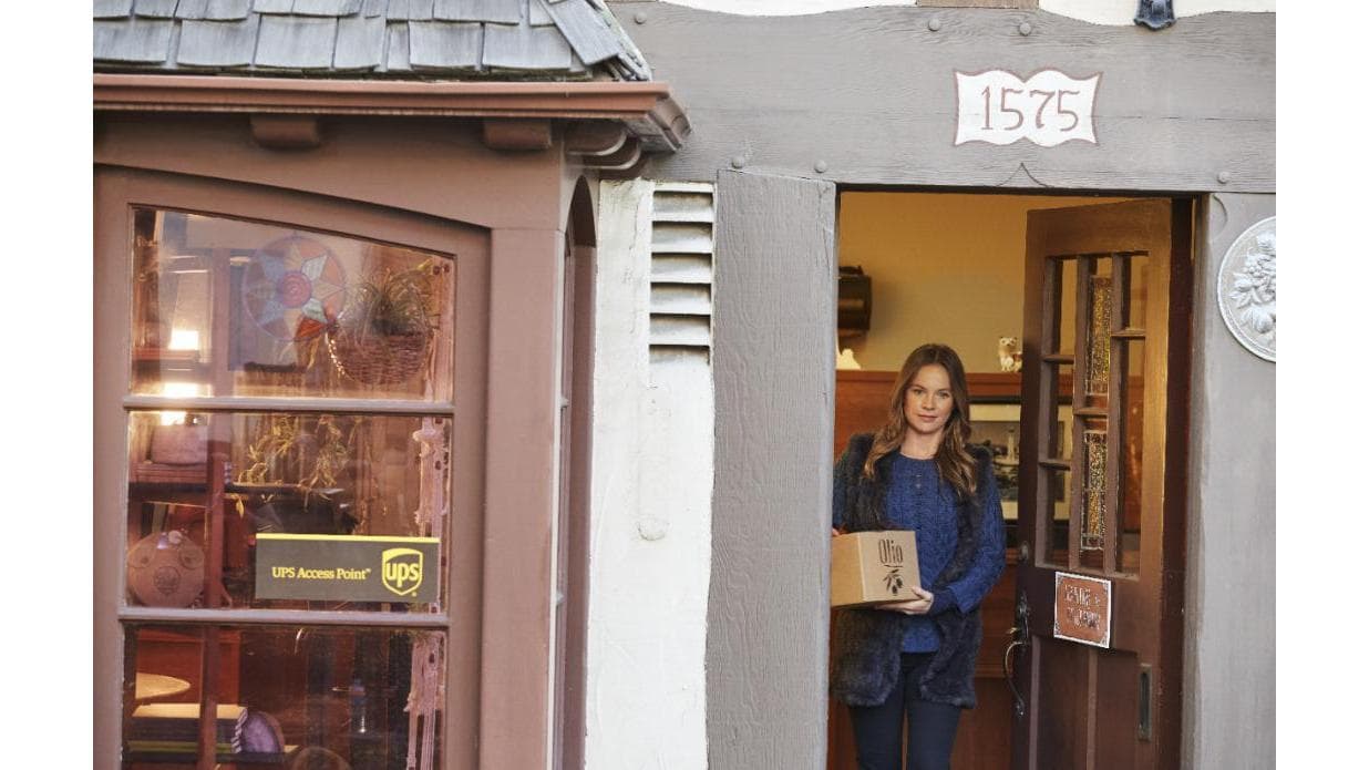 A woman holding a box stands at the entrance of a shop labeled "UPS Access Point" in Treeton, Yorkshire.