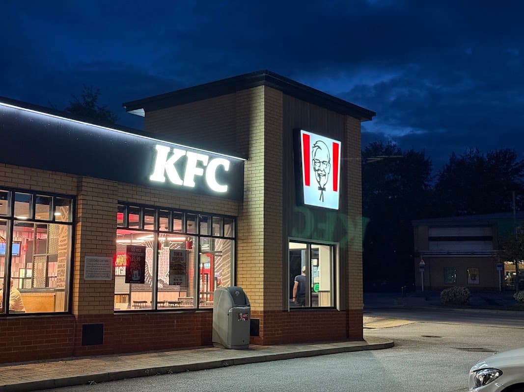 KFC restaurant exterior at night, featuring illuminated signage and a drive-thru area in Utley, Yorkshire.