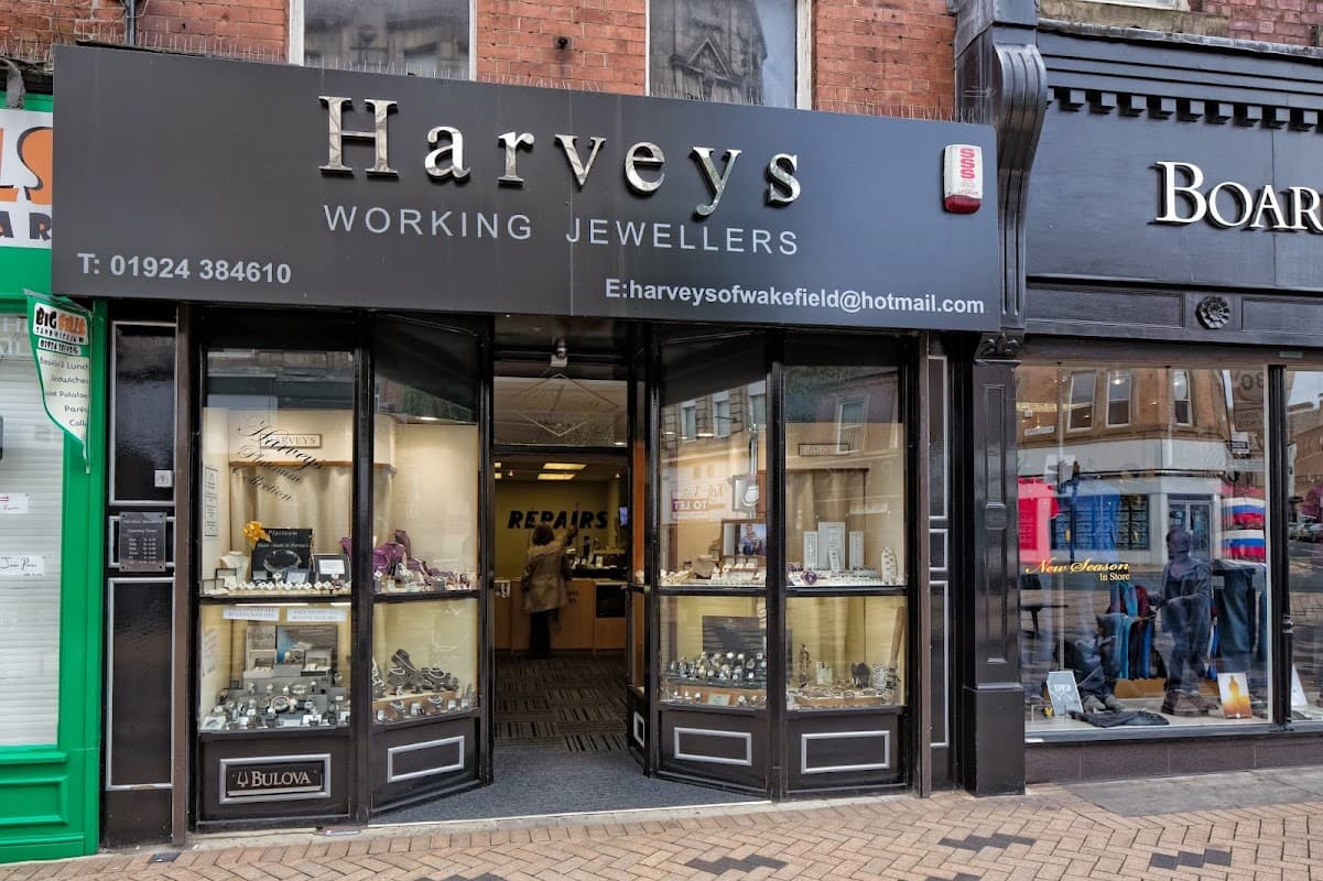 Harvey's Jewellers storefront with glass display cases showcasing jewelry and a sign for repairs.