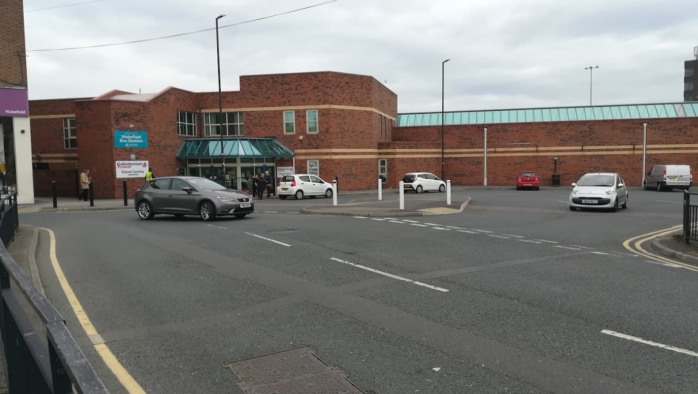 Entrance to Providence Street 2 Car Park with parked cars and a brick building in Wakefield, Yorkshire.