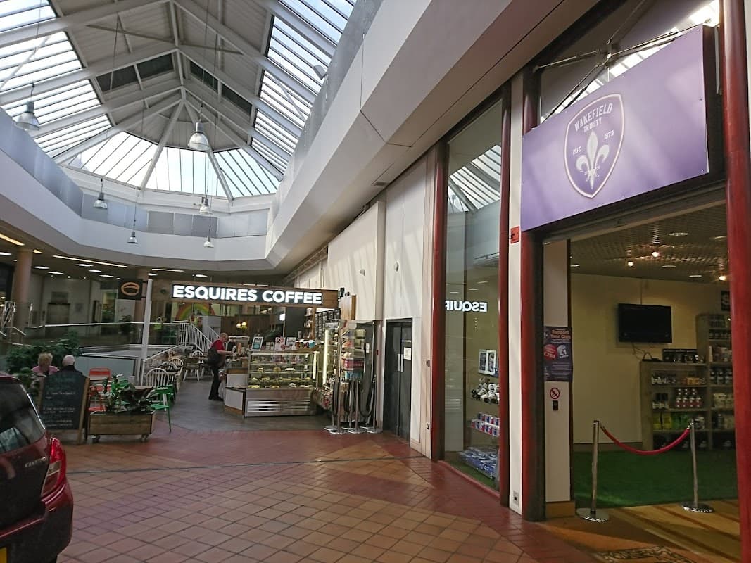 Bright atrium with skylights, featuring Esquires Coffee and a car wash entrance in The Ridings Shopping Centre.