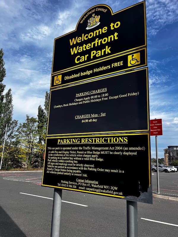 Sign for Waterfront Car Park in Wakefield, detailing parking charges, hours, and restrictions for disabled badge holders.