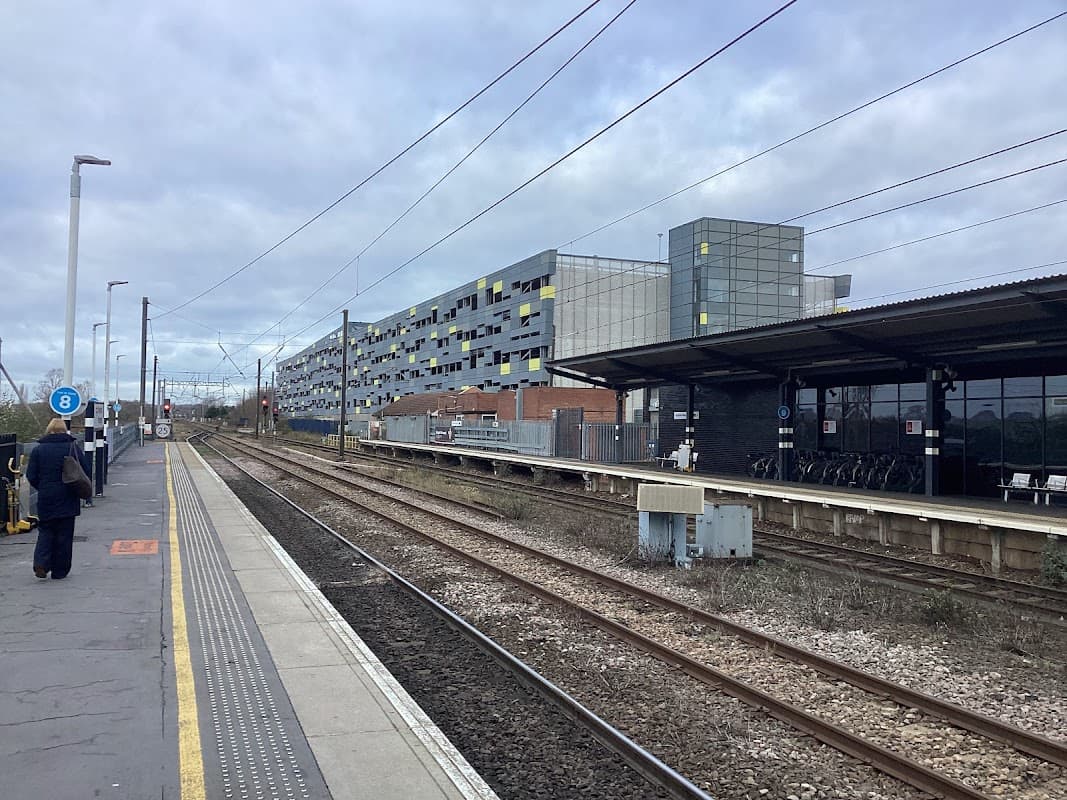 Bus stops at Wakefield Westgate with railway tracks, modern buildings, and cloudy skies in the background.
