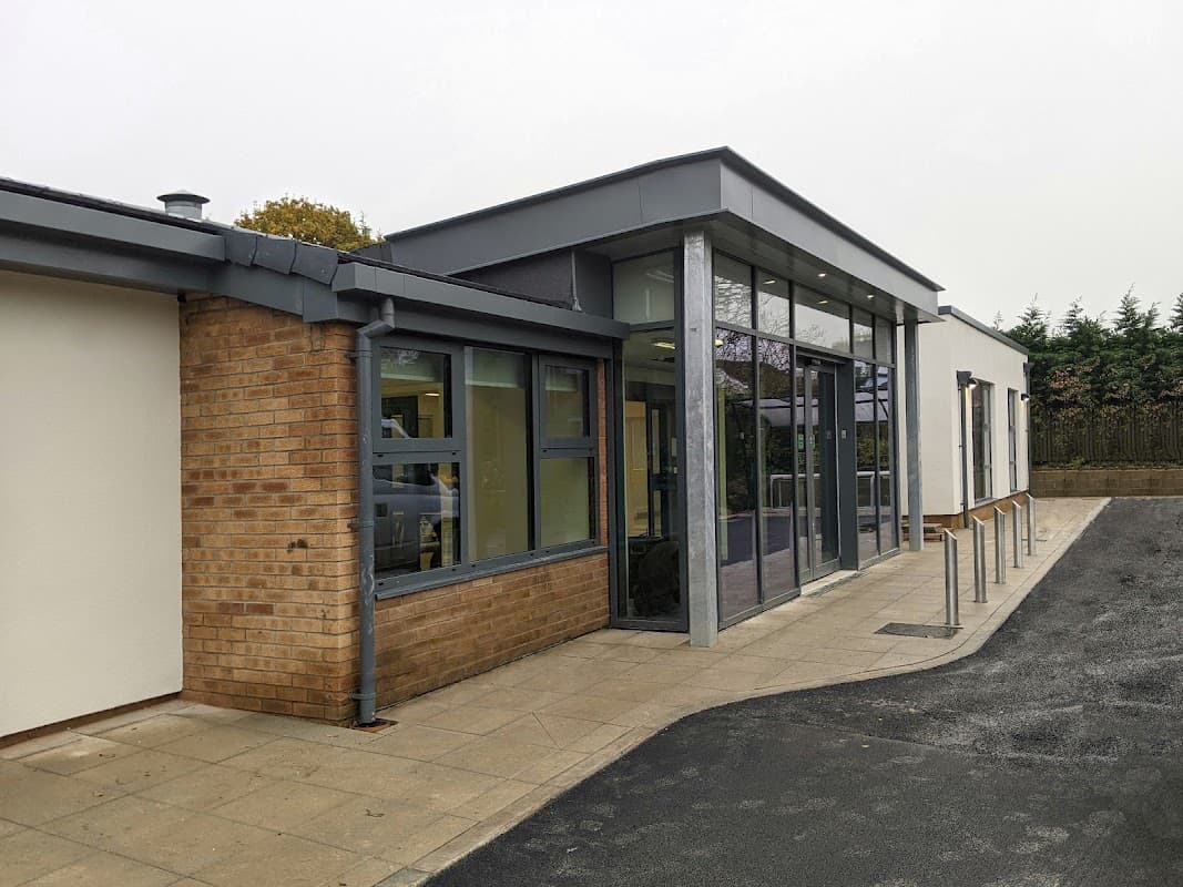Modern library and café building with large glass windows, brick exterior, and accessible entrance in Wigginton, Yorkshire.