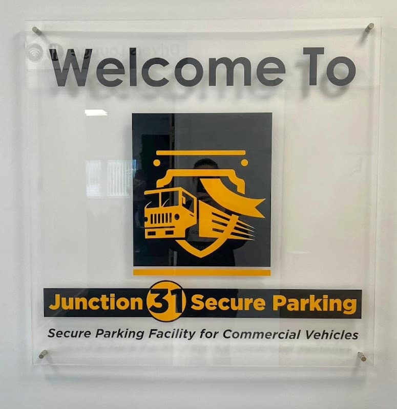 Welcome sign for Junction 31 Secure Parking, featuring a truck graphic and text highlighting commercial vehicle parking.