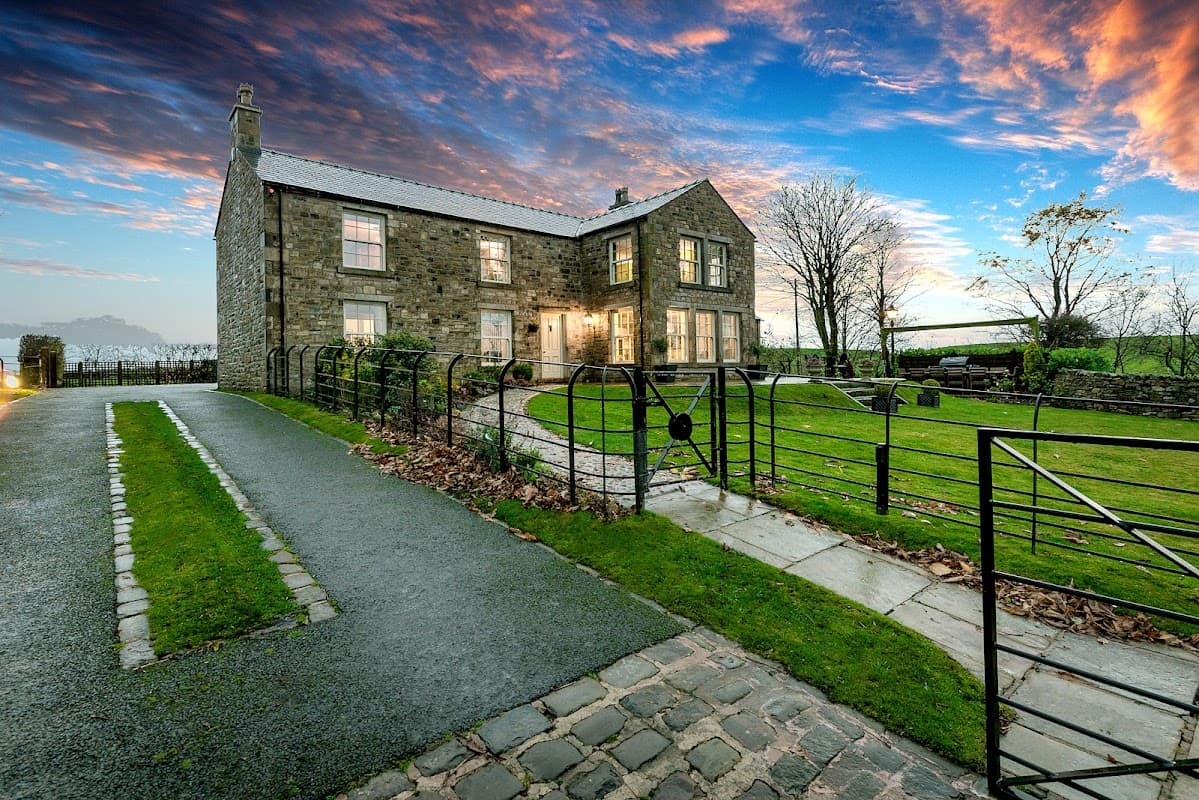 Wigglesworth House features stone architecture, a manicured garden, and a scenic sky at dusk in Wrigglesworth, Yorkshire.