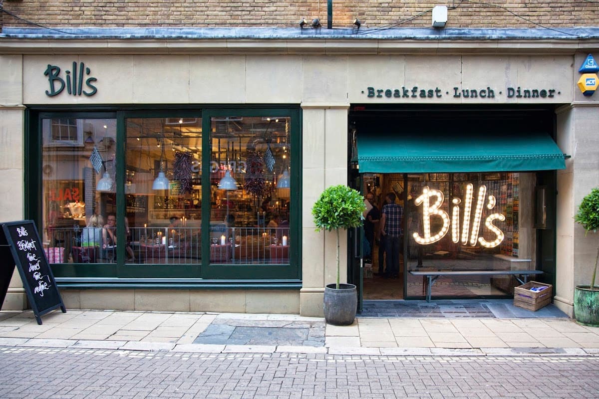 Charming restaurant exterior with green windows, a welcoming sign, and outdoor plants in York, Yorkshire.