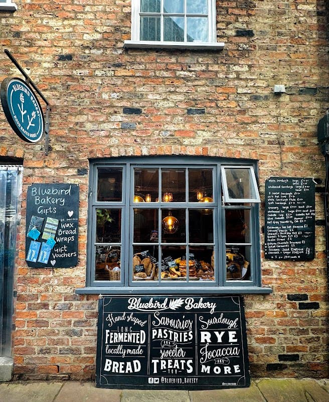Charming bakery with a rustic brick facade, window display of baked goods, and chalkboard menu.