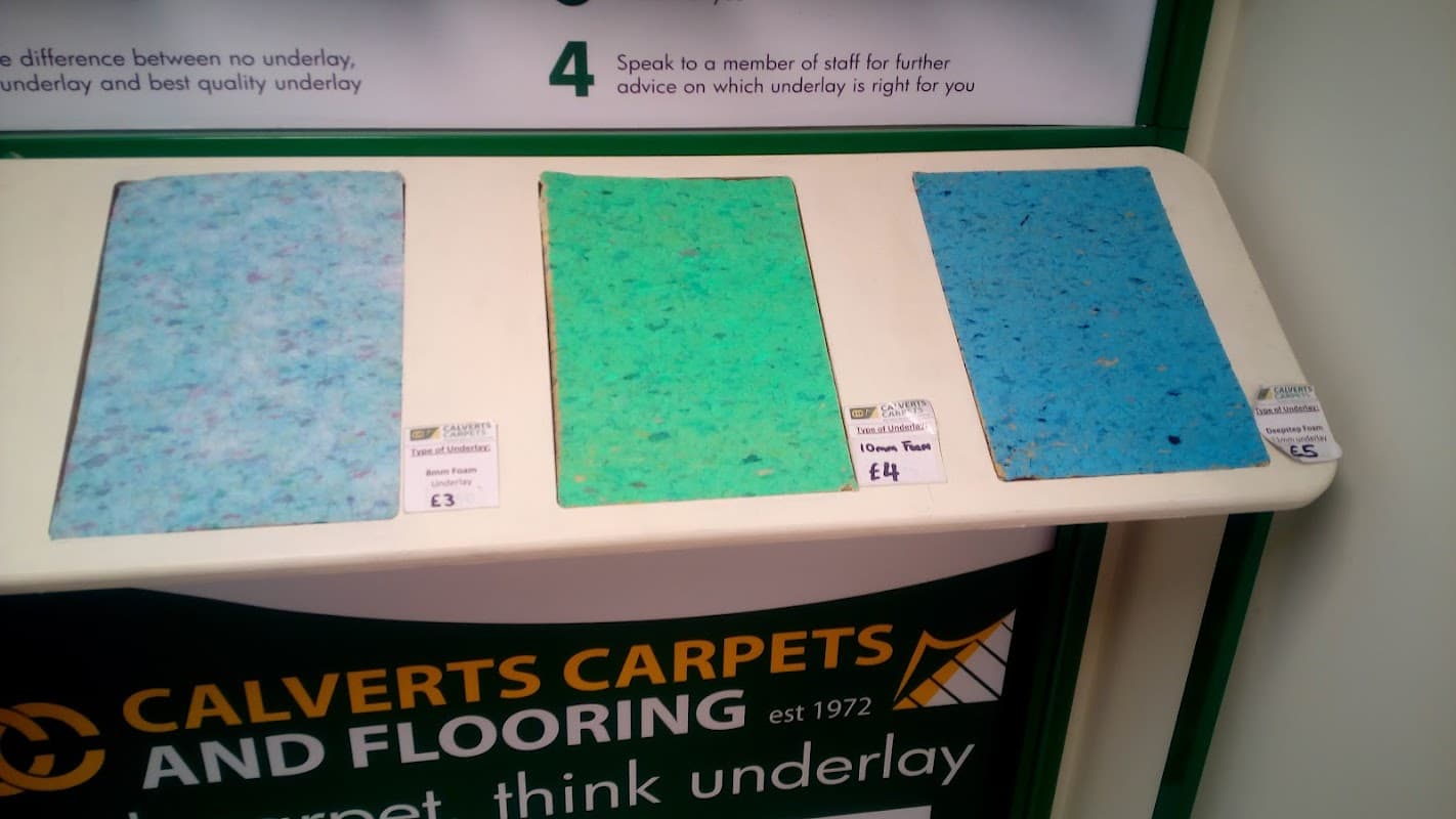 Three carpet underlay samples in varying shades of blue and green, with price tags displayed underneath.