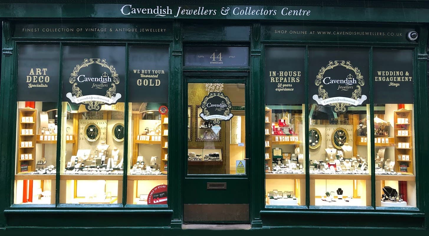 Storefront of Cavendish Jewellers featuring vintage and antique jewellery displays, with a sign and warm lighting.