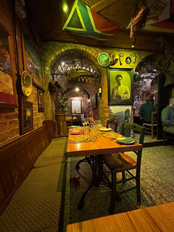 Cozy restaurant interior with wooden tables, vintage decor, and South African flags hanging from the ceiling.