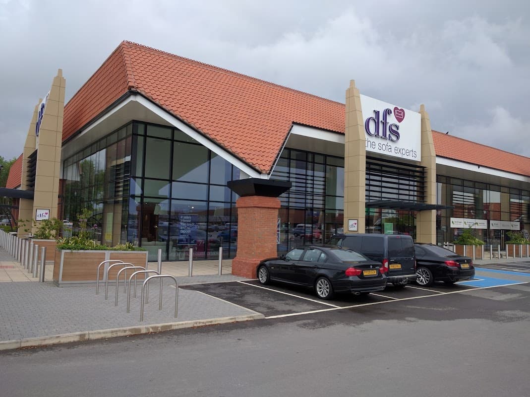 Modern furniture store with large glass windows, red tiled roof, and parking area in York, Yorkshire.